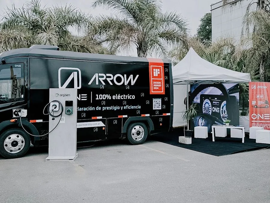 Colectivo eléctrico Arrow rotulado, junto al stand de la marca en un evento
